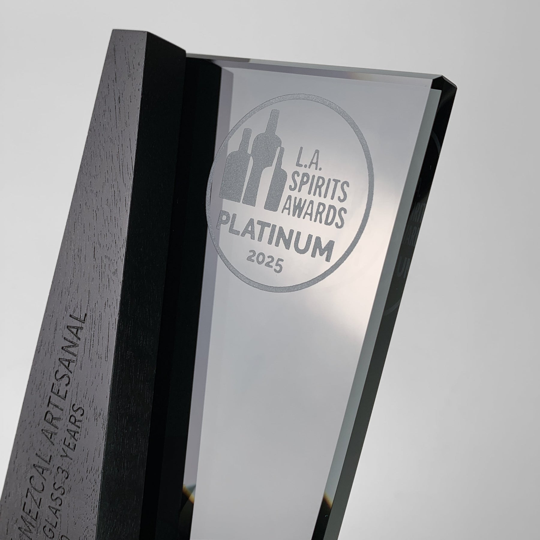Close-up of a modern corporate award from Trophyology’s DI/MI Collection, featuring laser-engraved wood and glass recognizing the 2025 L.A. Spirits Awards Platinum winner.