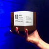 Custom walnut and white paint engraved award for AIA Austin being held over a bold blue background.