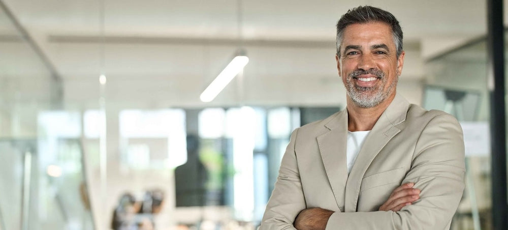 Man standing in a modern office setting representing employee recognition strategies that influence retention and workplace engagement