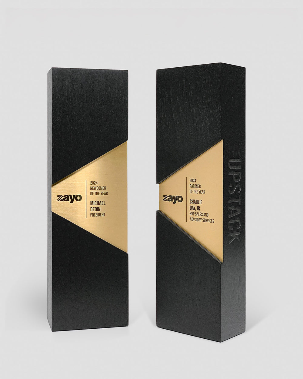Front view of custom Figura Trapezium Awards designed for Zayo as Partner of the Year Awards, with precision-cut walnut, brass inlay plates, and modern minimalist branding.