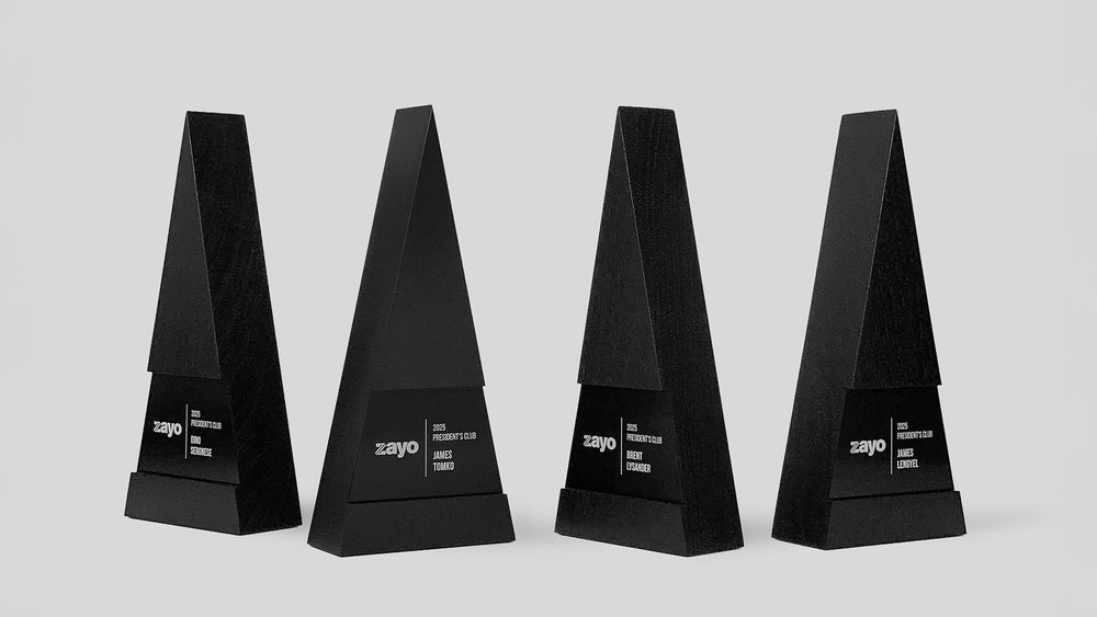 Collection of custom Figura Trigonum Awards crafted by Trophyology for Zayo, highlighting the unified geometric design and individually engraved honoree details.