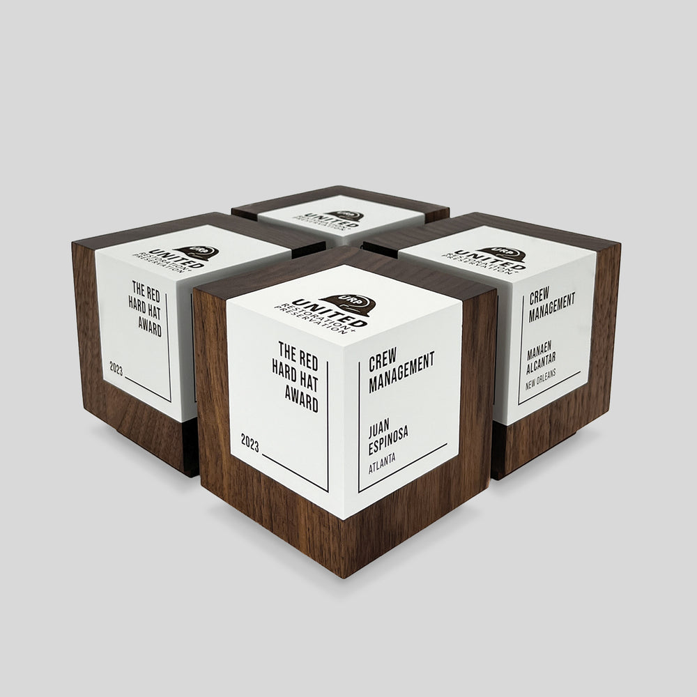 Geometria Award Cubus: a minimalist wooden trophy cube with white engraved nameplates, representing stability and precision. Crafted from solid walnut or maple, ideal for personalized recognition. Architect-designed and artisan-crafted in the USA. 