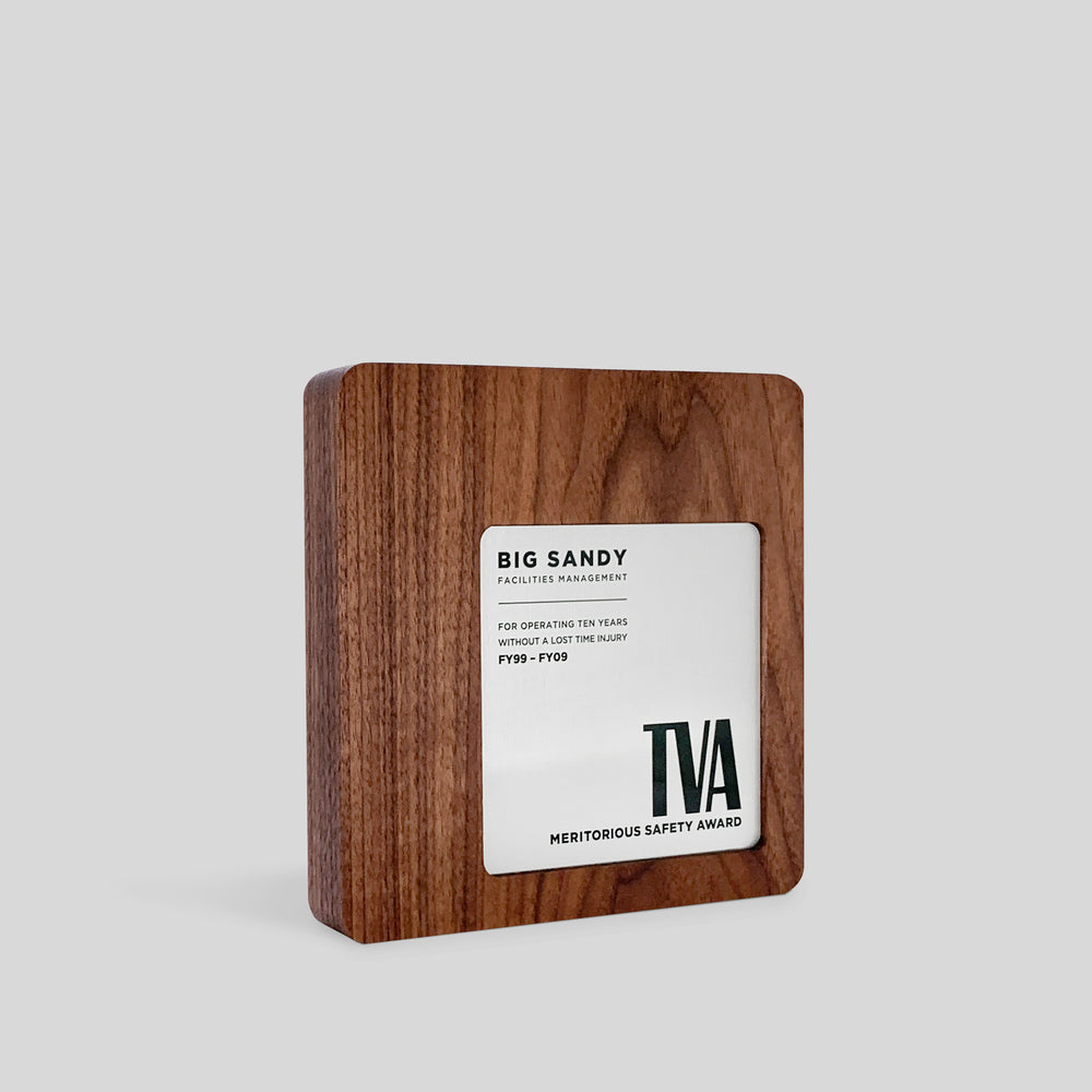 Figura Quadrato Plaque: a wooden recognition plaque with a square engraved and personalized nameplate, featuring metal accents and a minimalist design, embodying modern elegance and individuality.