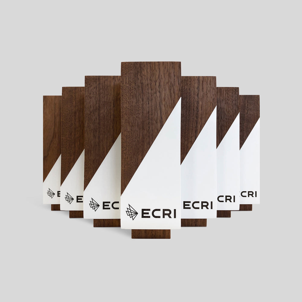 Geometria Award Triangulus: wooden triangular design with engraved labels, showcasing sleek lines and wood grain, epitomizing precision and excellence in a minimalist aesthetic.