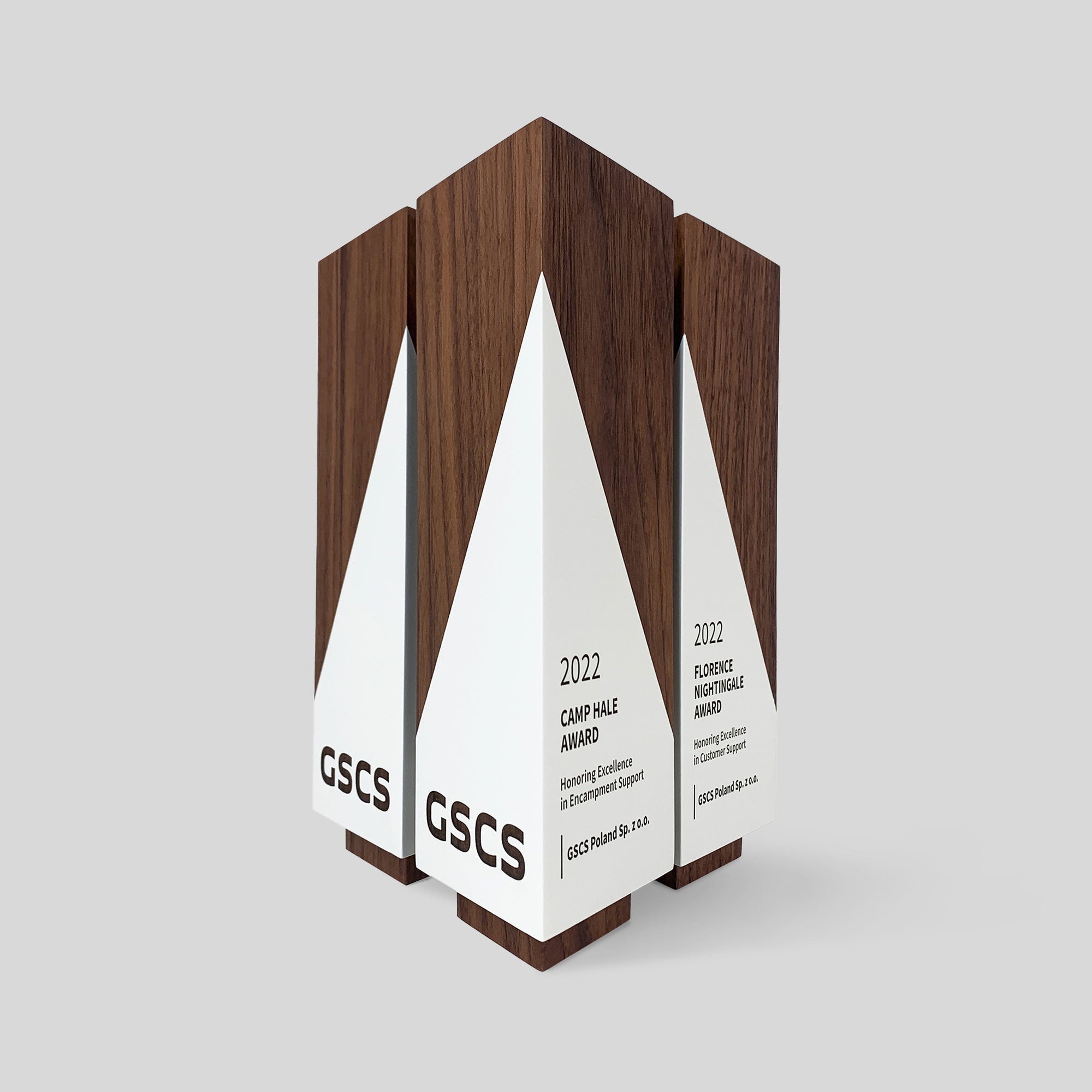 Geometria Award Triangulus: a group of wooden trophies showcasing modern, angular design, crafted from solid walnut or maple, highlighting precision and excellence.