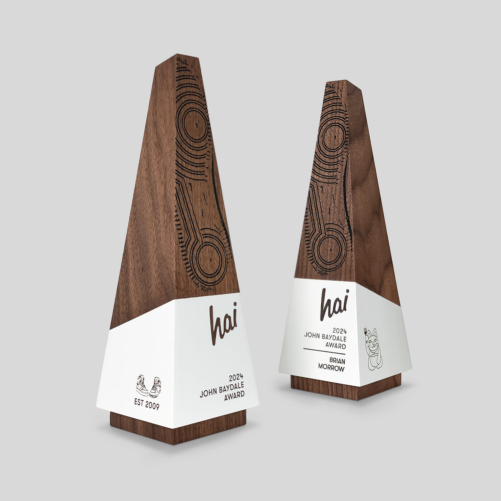 Geometria Award Obeliscus, featuring sleek wooden design with engraved white labels, symbolizes ambition and excellence, crafted from rich walnut or maple.