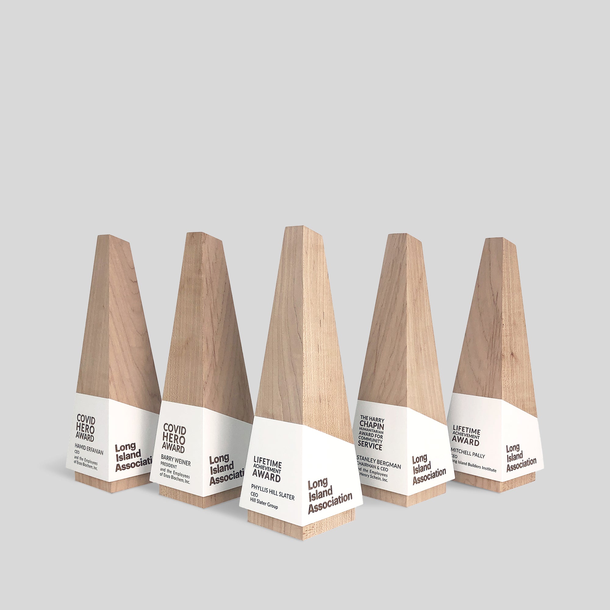Geometria Award Obeliscus: Wooden obelisk-shaped trophy with white accents, symbolizing strength and ambition, crafted from solid walnut or maple with customizable engraving options.