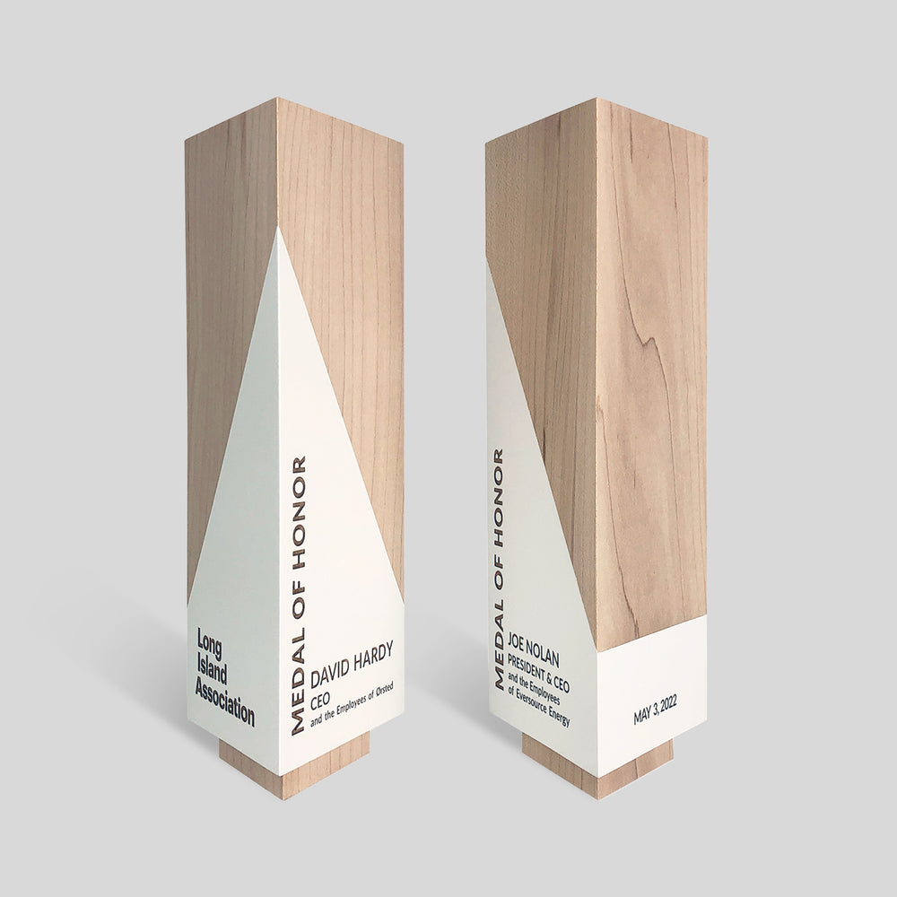 Geometria Award Triangulus, a sleek triangular wooden award with engraved text, embodies precision and elegance, showcasing artisan craftsmanship and modern design.