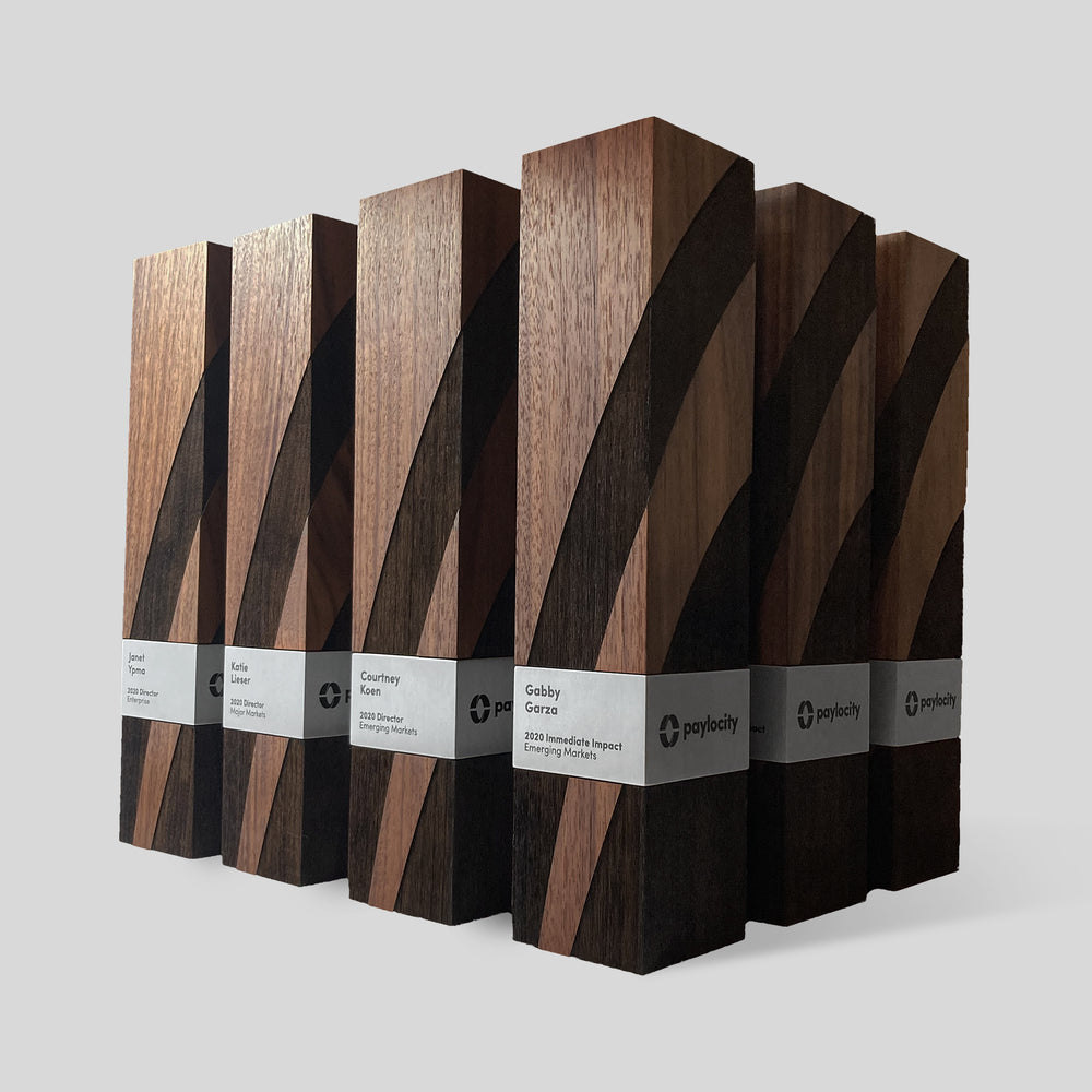 Stela Square Award | Large, featuring minimalist wooden blocks with black ribbons and white labels, embodying strength and elegance, crafted from walnut or ebony with metal accents.