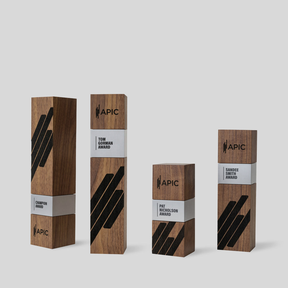 Stela Square Award | Large: A collection of wooden boxes featuring black and white labels and logos, showcasing elegant, architect-designed awards for exceptional achievements.