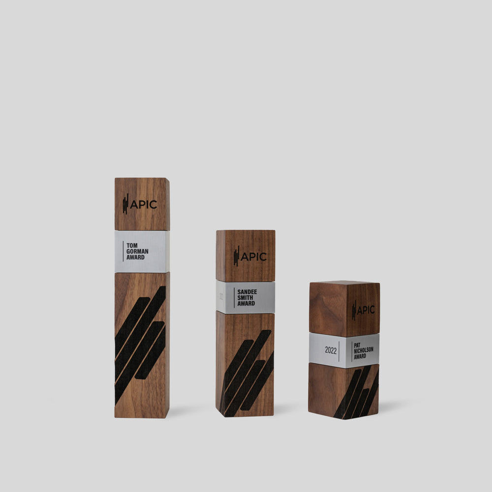 A set of modern executive awards crafted from walnut wood with engraved branding and customized metal accents. Elegant and contemporary recognition pieces for excellence.