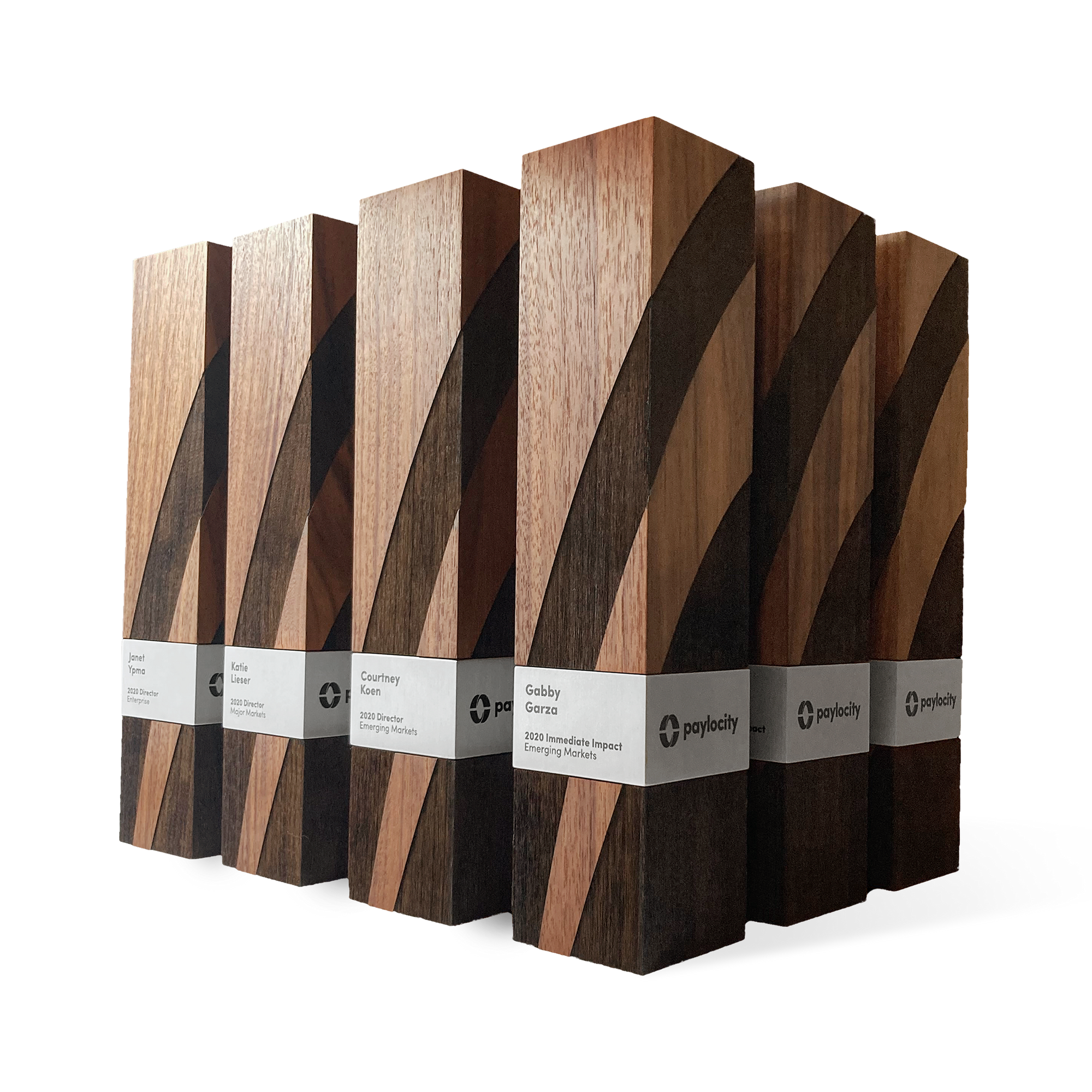 A collection of handcrafted executive awards made from rich wood with bold geometric engraving and metal nameplates. Modern, elegant recognition for excellence.