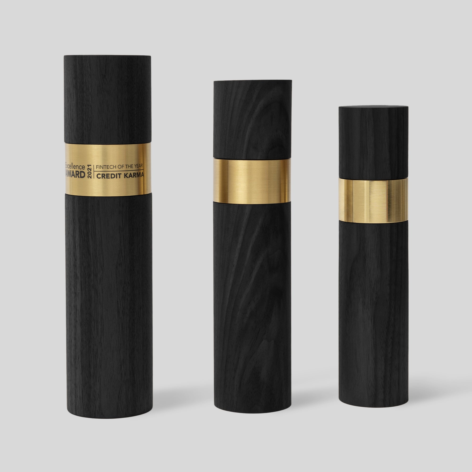 Stela Round Award | Small: Black and gold cylindrical design symbolizing unity, featuring a luxurious metal ring and wood base. A tribute to excellence and achievement.