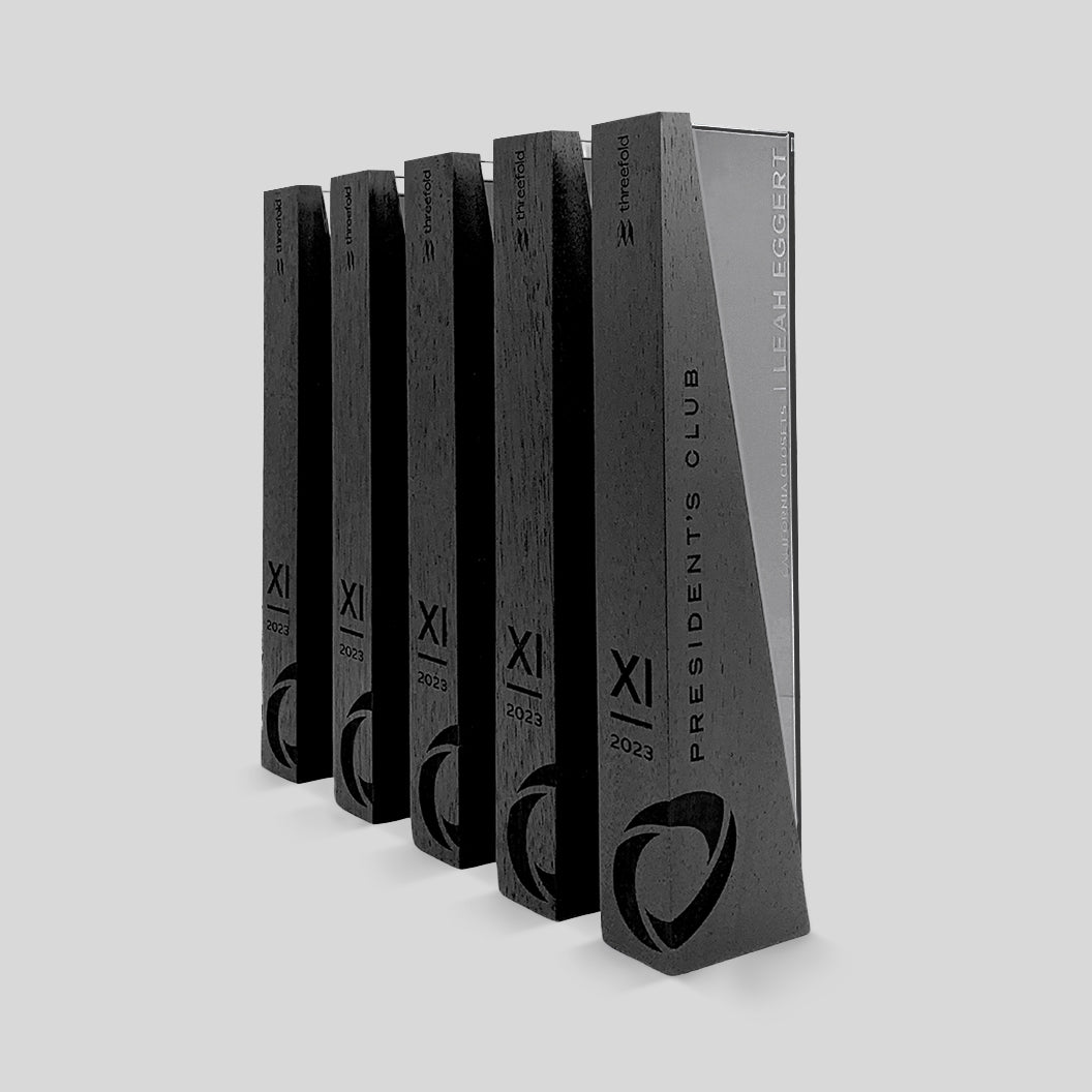 DI/MI Awards, showcasing interlocking wood and glass elements with a dynamic angled design, exemplifying sophistication and innovation in a modern, elegant trophy, engraved on the wood and glass.