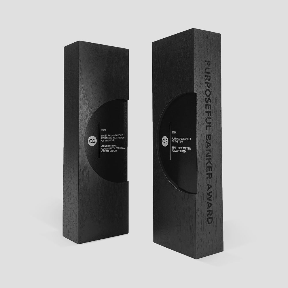 Figura Ellipsum Award, a black rectangular box featuring a cut-out window, symbolizing commitment and crafted with walnut, maple, and metals for a stunning presentation.