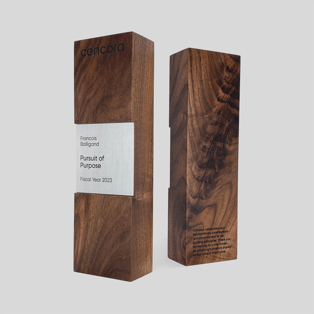 Figura Quadrum Award: A wooden box with a silver nameplate, showcasing refined craftsmanship with walnut and maple, symbolizing stability and strength.