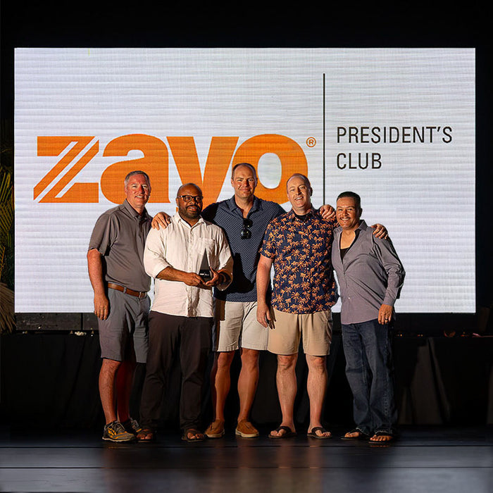 Zayo President’s Club honorees receiving their custom Trophyology awards on stage, displaying the custom Figura Trigonum trophy during the celebration ceremony.