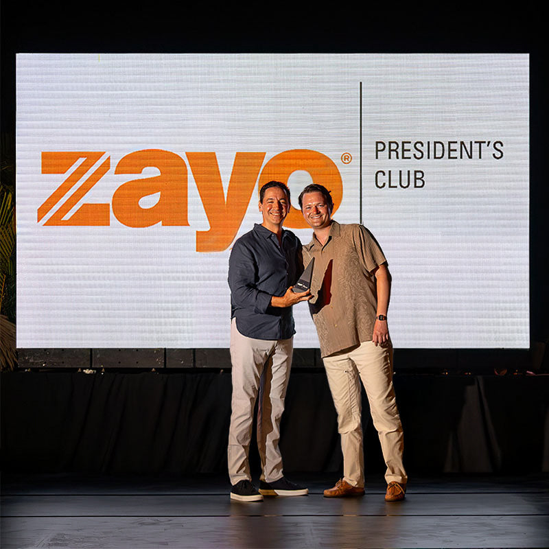 Honoree receiving Trophyology’s custom award during Zayo President’s Club presentation.