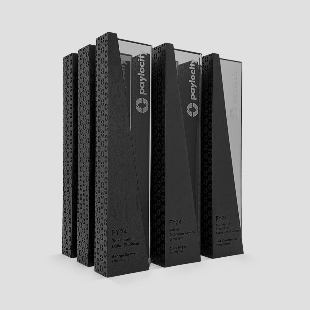 Custom sales awards by Trophyology featuring engraved brand pattern, ebony-stained wood, and interlocking glass in a bold geometric design—created for Paylocity’s honorees.