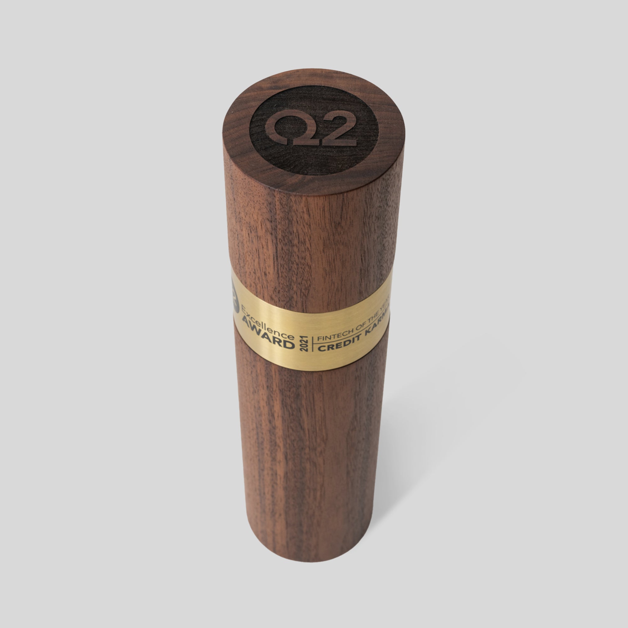 Stela Round Award features a solid wooden cylinder with an engraved gold brass band, symbolizing prestige and achievement. Architect-designed and artisan-crafted in the USA. Unique, minimalist and modern trophy design.
