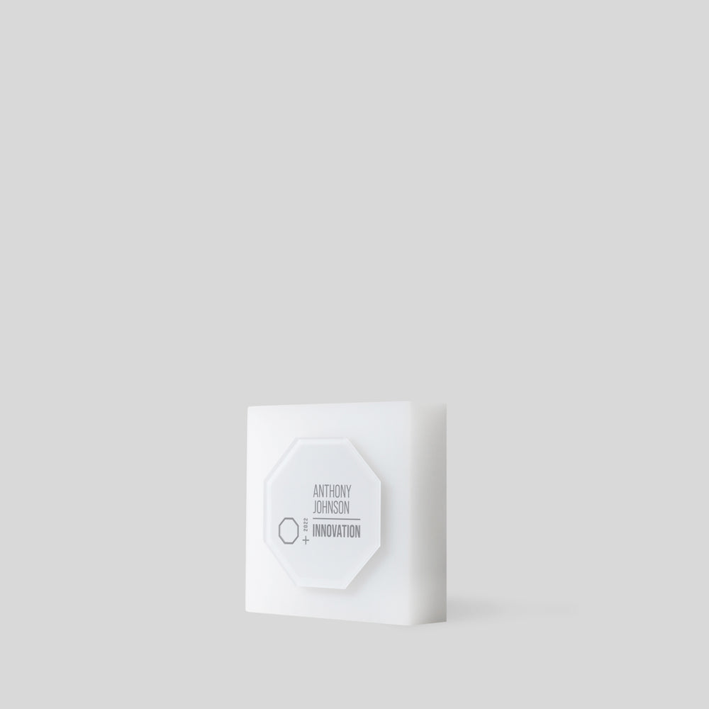 Glacio Award Octagon with a frosted geometric design, featuring a hexagonal label on a square base, symbolizing transformation and achievement for personalized recognition. Satin-white acrylic trophy made in the USA.