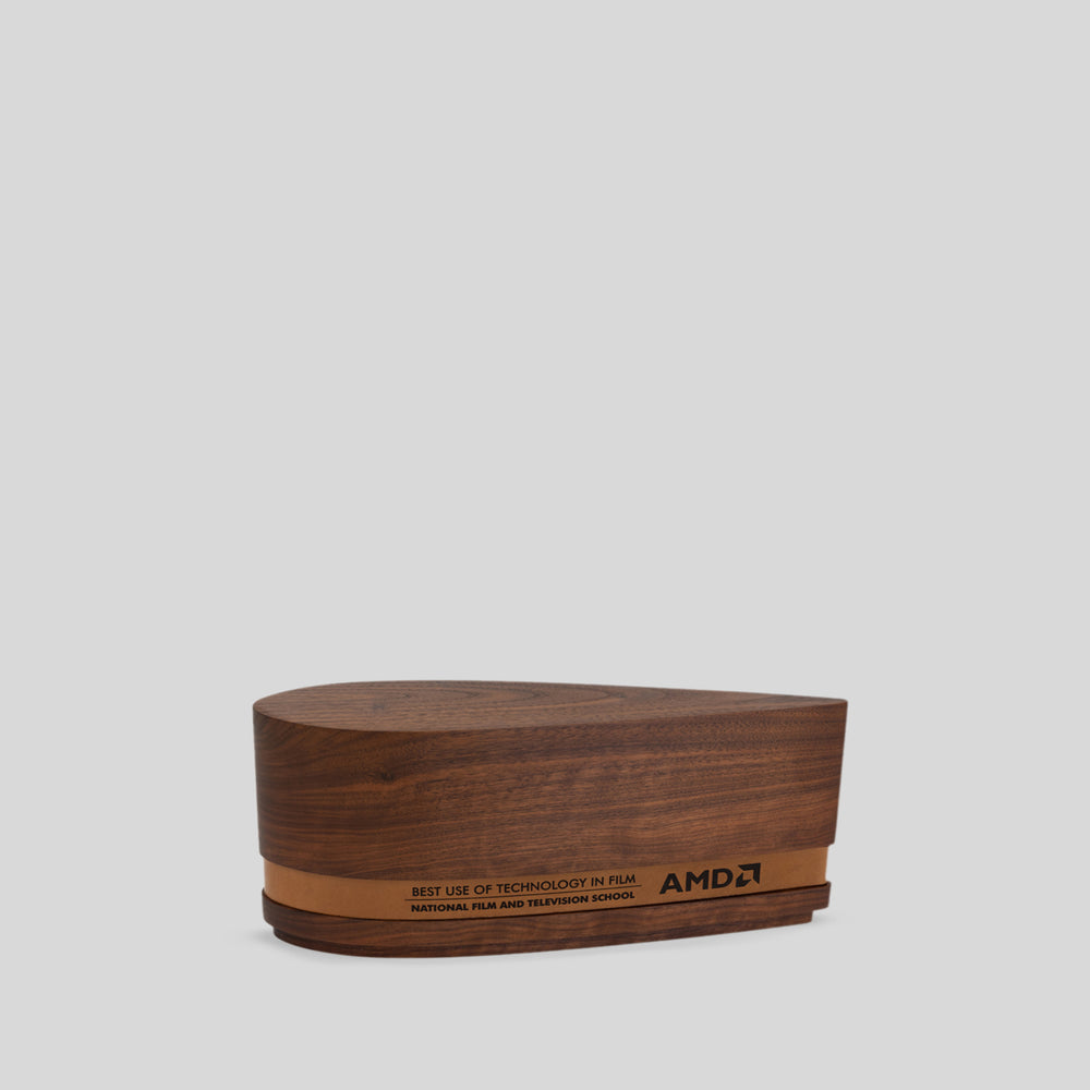 Ovali Award: Wooden box with a leather-wrapped walnut body, showcasing fluid design inspired by kayaks, symbolizing harmony and progress.