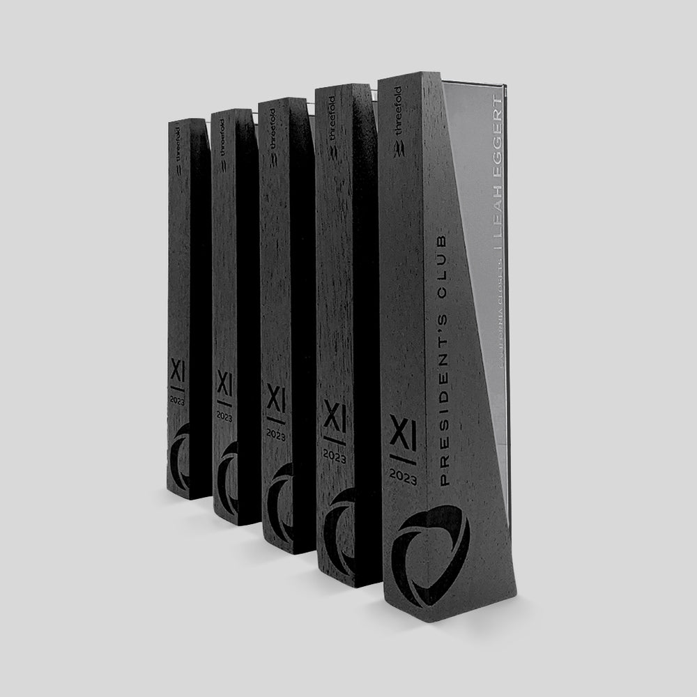 DI/MI Awards, showcasing interlocking wood and glass elements with a dynamic angled design, exemplifying sophistication and innovation in a modern, elegant trophy, engraved on the wood and glass. Personalized as elegant President&#39;s Club trophies. 